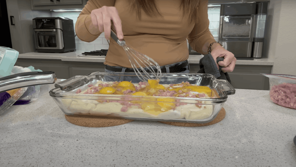 Lindsey whisking the eggs she cracked into the glass baking dish