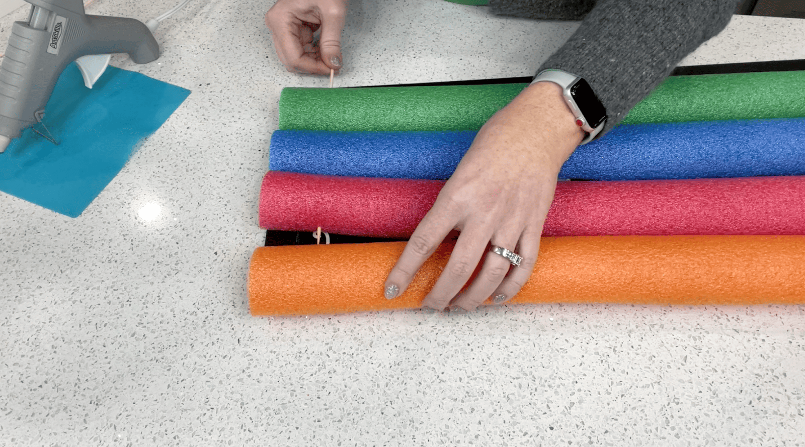 Lindsay lining up her pool noodles along the sign